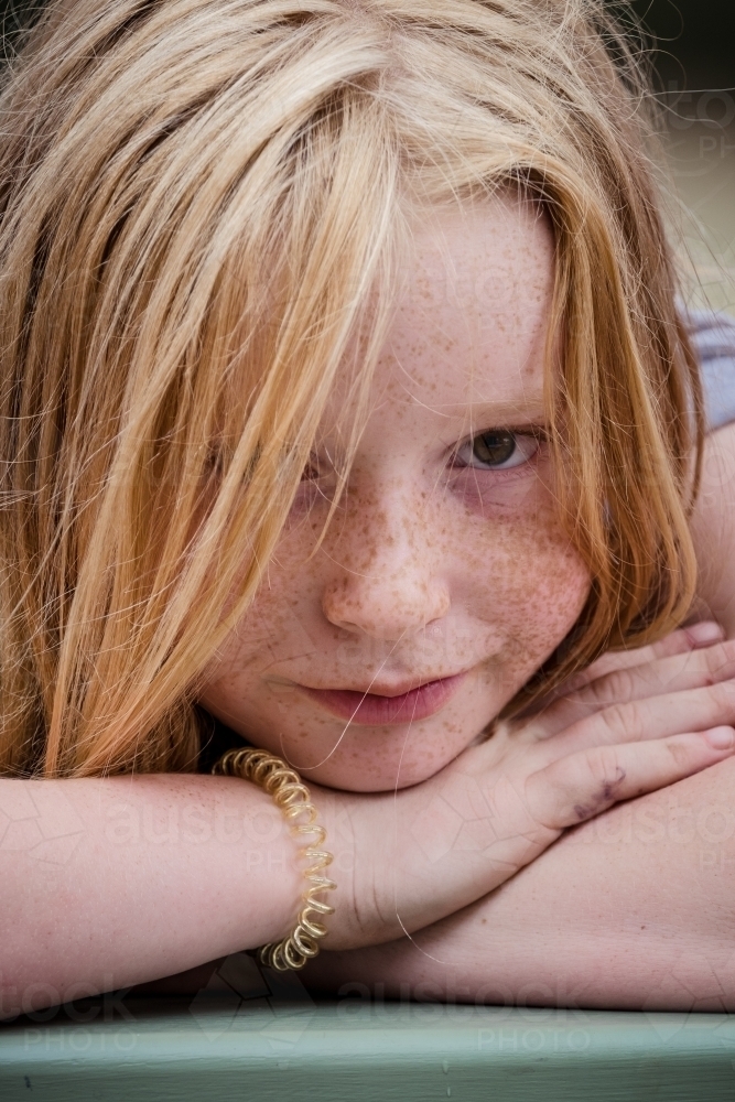 Young girl with beautiful freckles looks at the camera. - Australian Stock Image