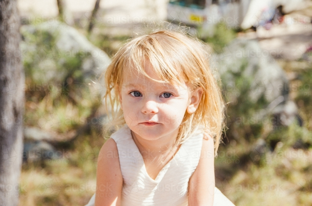 Young girl with blonde hair outdoors under the sun - Australian Stock Image
