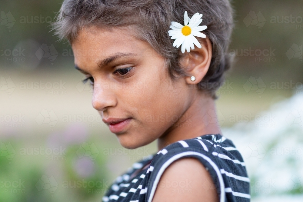 Image of young girl with daisy in her hair - Austockphoto