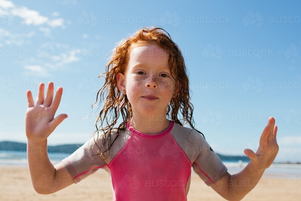 Image of Young girl with her hands up at the beach - Austockphoto