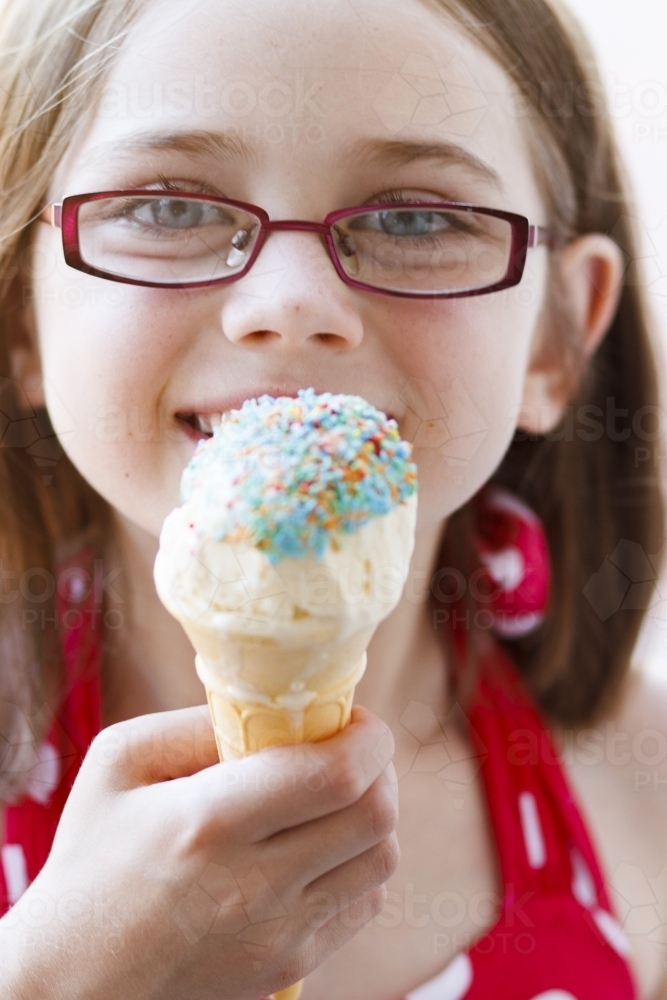 Young girl with ice cream covered in sprinkles - Australian Stock Image