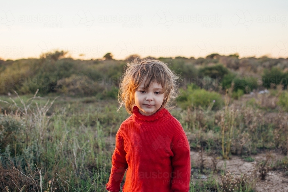 Young girl with messy hair standing in bushland - Australian Stock Image