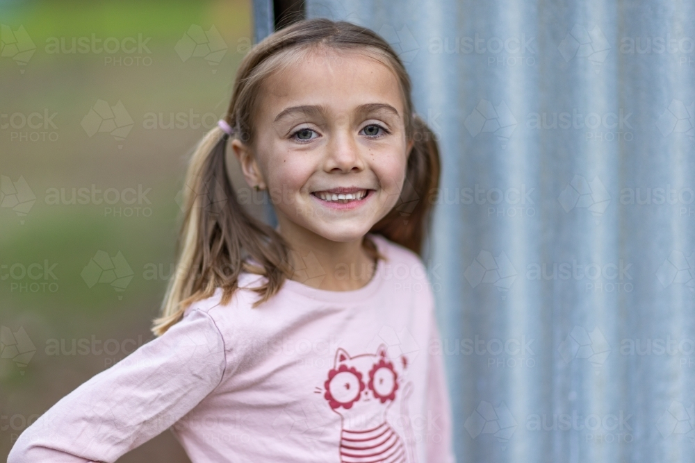 Young girl with pigtails smiling - Australian Stock Image