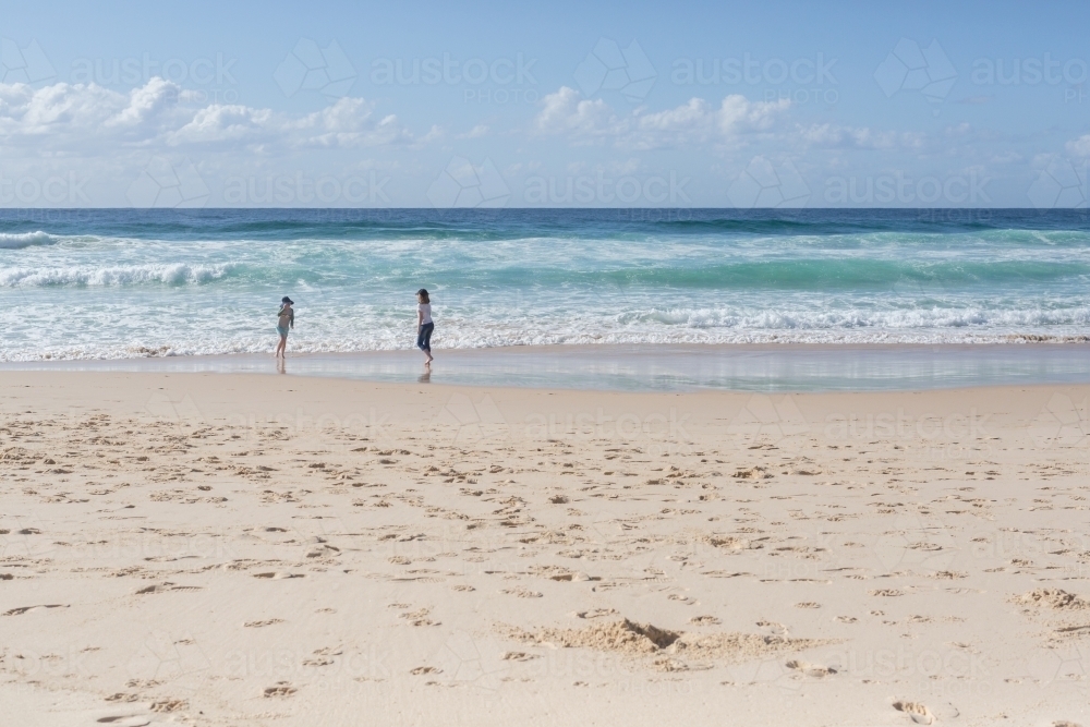 Young girls on a beach looking out to sea - Australian Stock Image