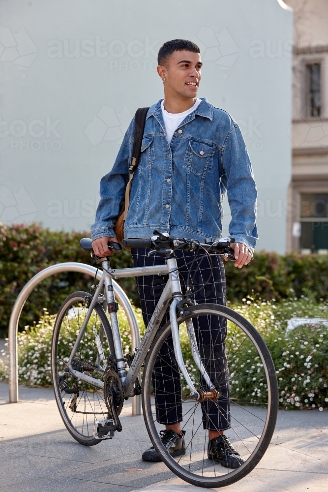 Young Indigenous Australian man at park with bicycle - Australian Stock Image