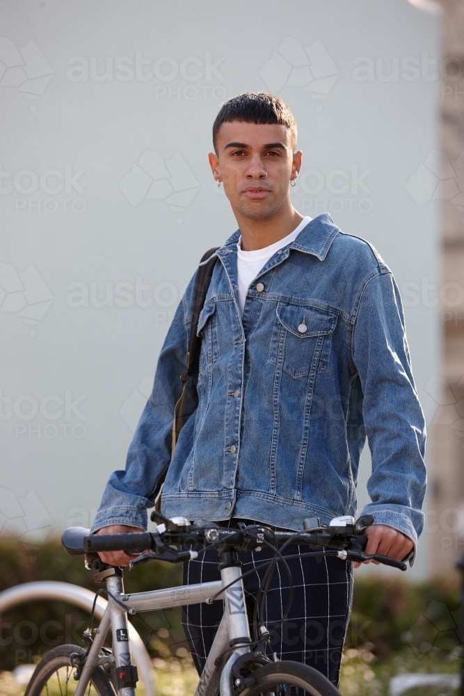 Young Indigenous Australian man at park with bicycle - Australian Stock Image