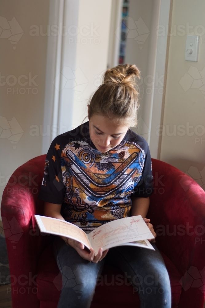 Young indigenous girl reading - Australian Stock Image