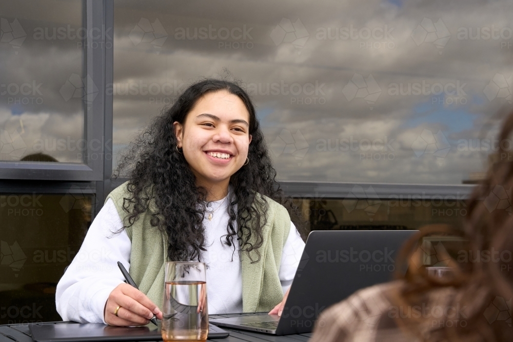 Young indigenous woman in study group with friend - Australian Stock Image