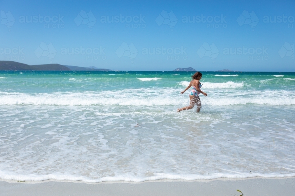 young lady running through the shallows on Middleton Beach - Australian Stock Image