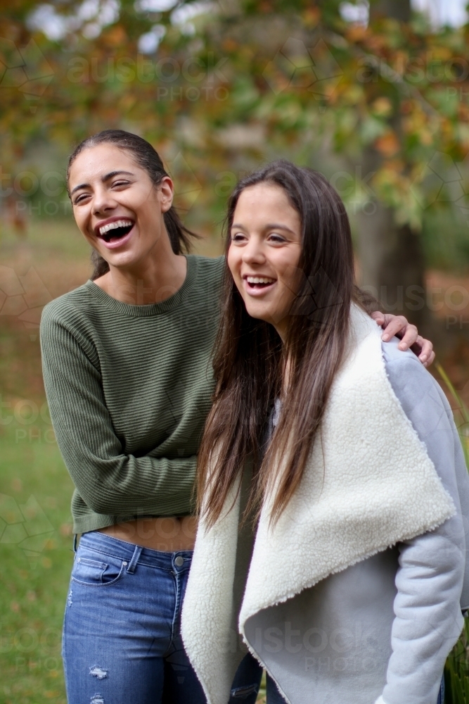Young lesbian couple hugging and laughing outdoors - Australian Stock Image