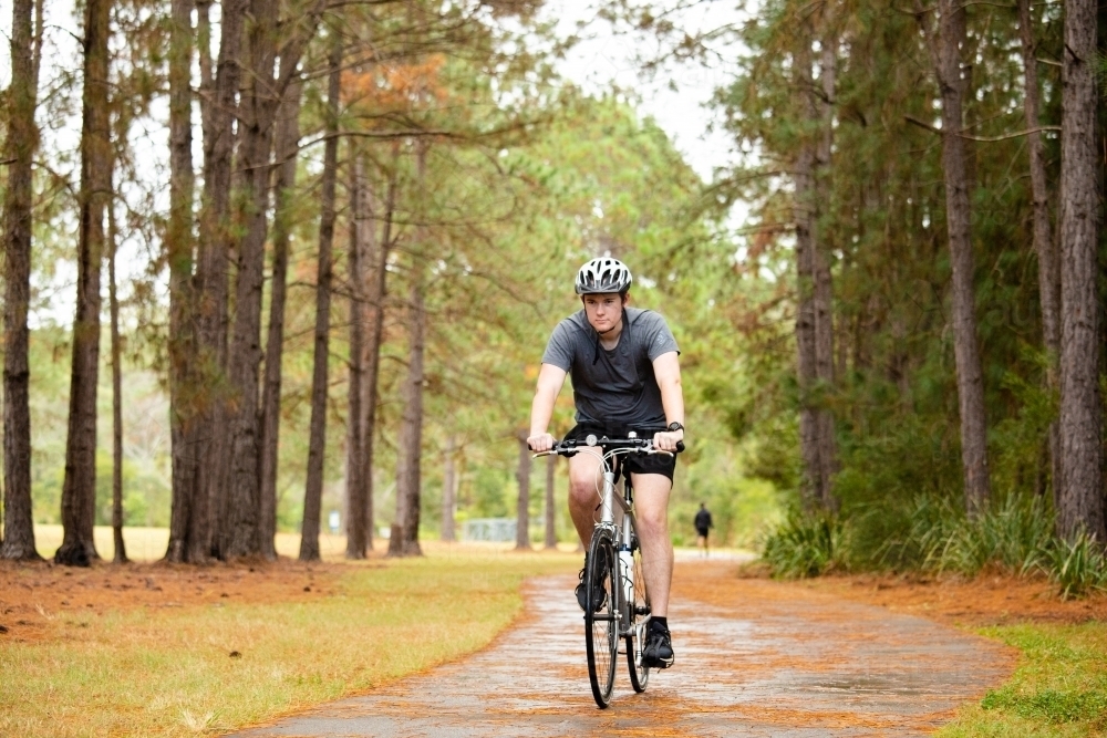 Young male cycling along a parkland bike path - Australian Stock Image