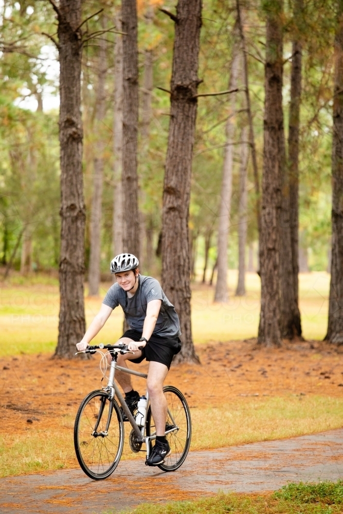 Young male cycling along a parkland bike path - Australian Stock Image
