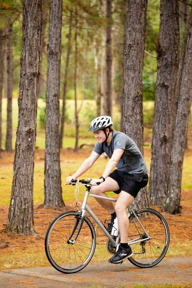 Young male cycling along a parkland bike path - Australian Stock Image