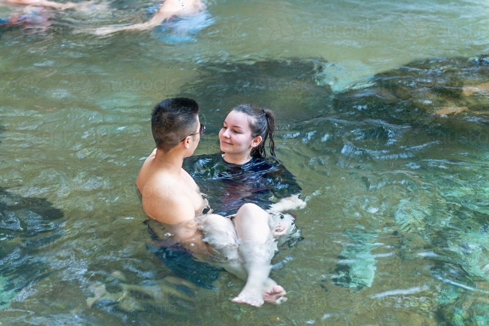 Young Male holding female in water - Australian Stock Image