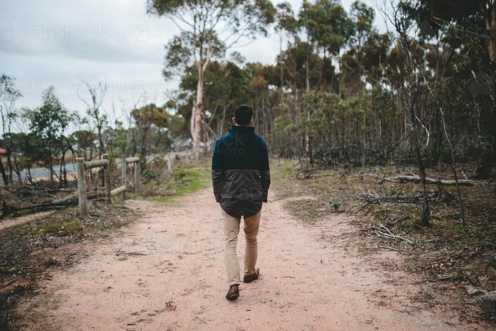 Young male walking in the bush from behind - Australian Stock Image
