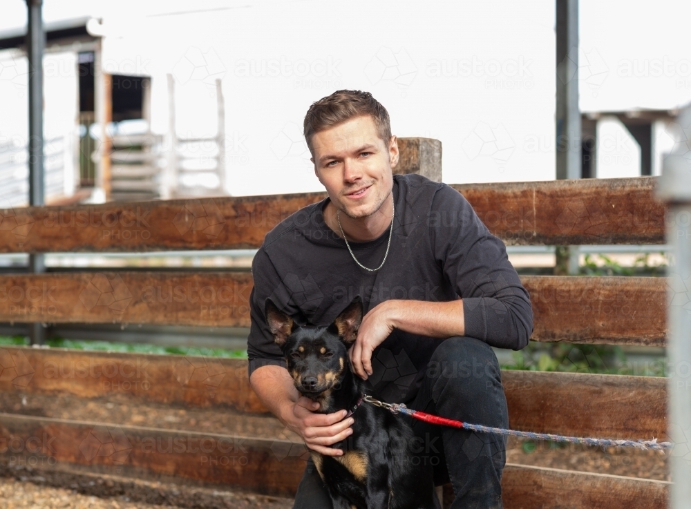 Young man in black with a kelpie dog - Australian Stock Image