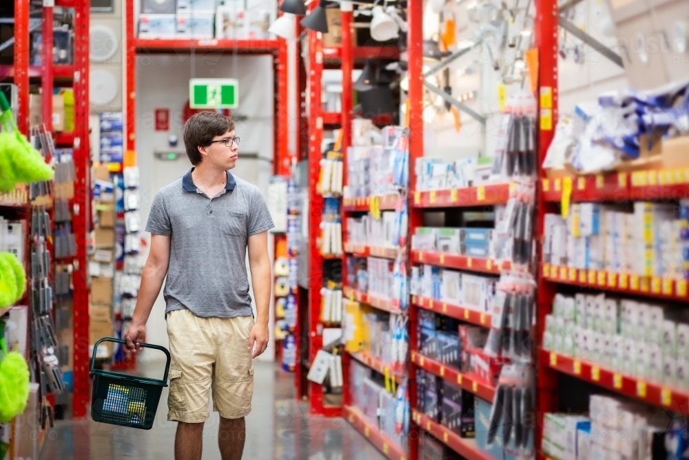 Young man in hardware store shopping for house improvement project - Australian Stock Image