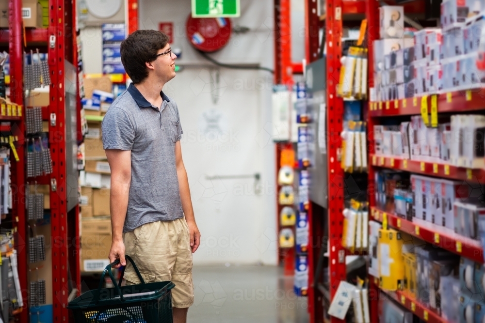 Young man in hardware store shopping for house improvement project - Australian Stock Image