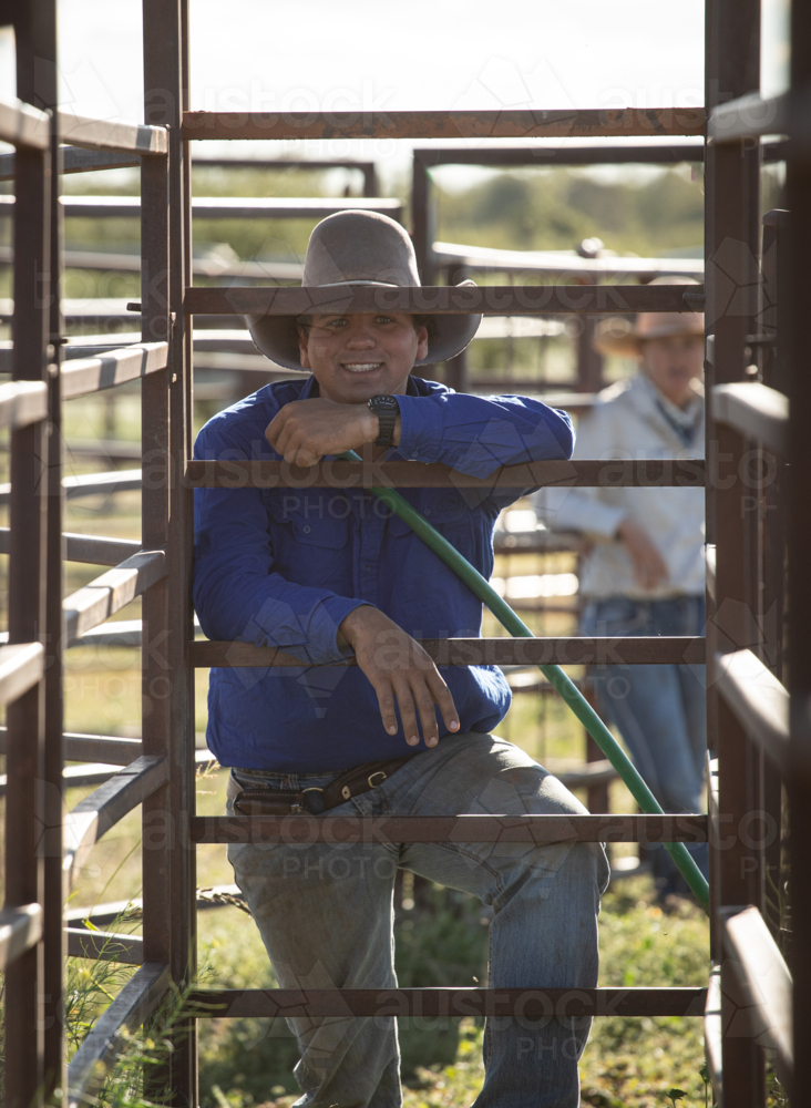 Young man leaning on the cattle yard gate - vertical - Australian Stock Image