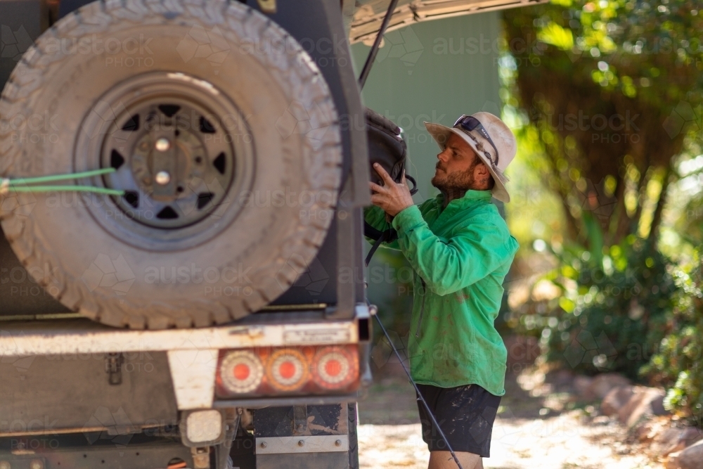 young man loading 4x4 for outback adventure - Australian Stock Image