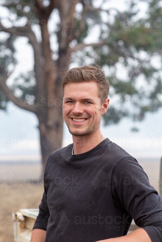 Young man outdoors with smoke in the background - Australian Stock Image