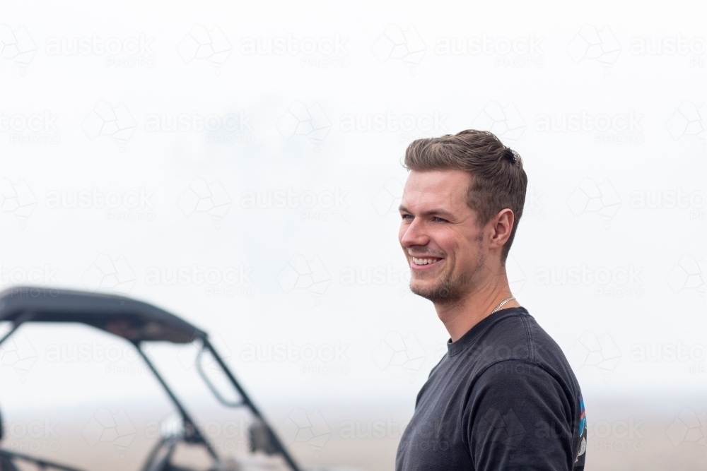 Young man outdoors with smoke in the background - Australian Stock Image