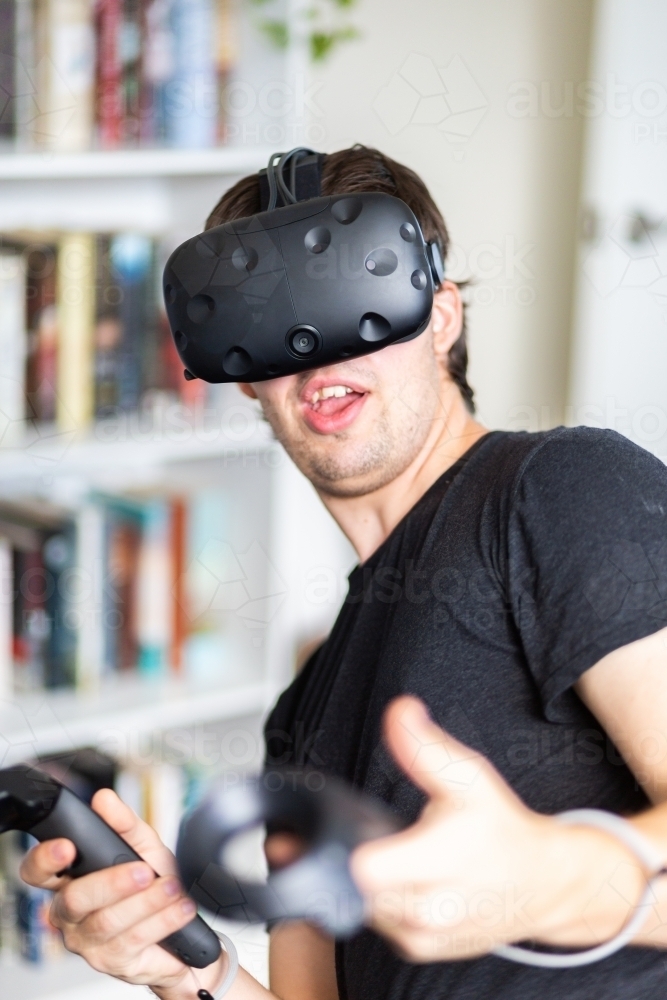 Image of Young man playing game with virtual reality technology inside ...