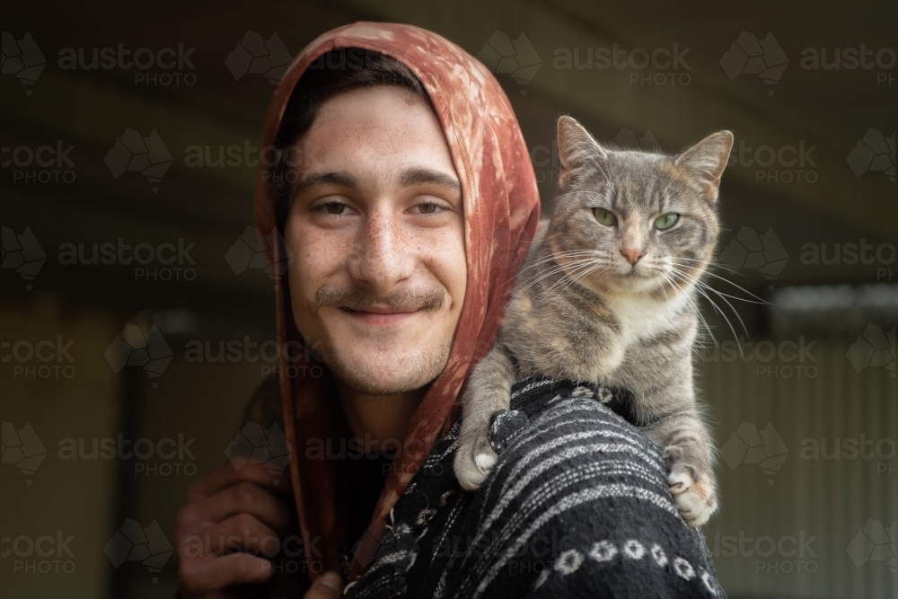 Young man posing with his pet cat - Australian Stock Image