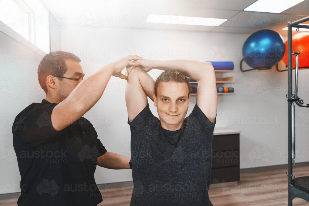Young man receiving physiotherapy treatment at clinic - Australian Stock Image