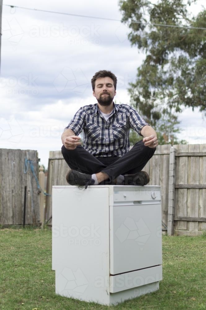 Young Man sitting on Dishwasher - Australian Stock Image