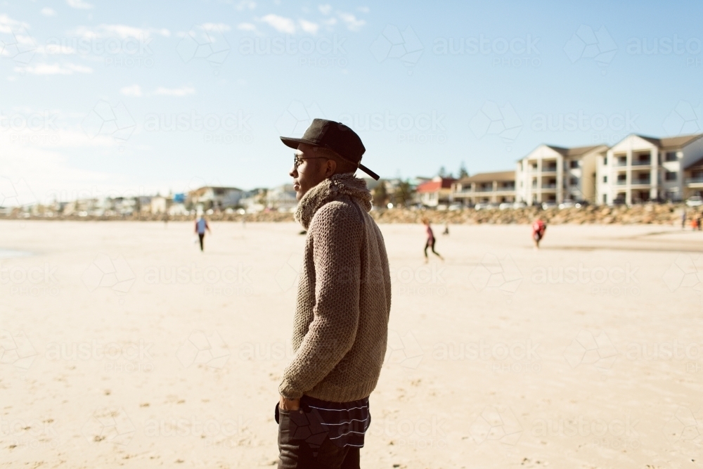 Young man standing on the beach looking away - Australian Stock Image