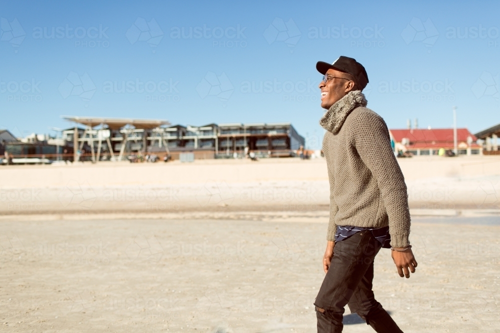 Young man standing on the beach smiling - Australian Stock Image