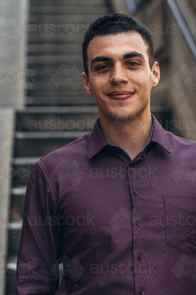 young man standing on the staircase smiling - Australian Stock Image