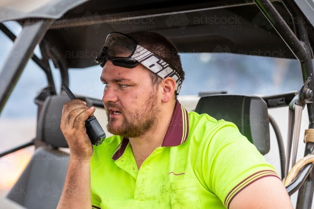 Young man talking on walkie-talkie two way radio - Australian Stock Image