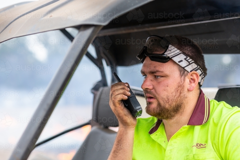 Young man talking on walkie-talkie two way radio - Australian Stock Image