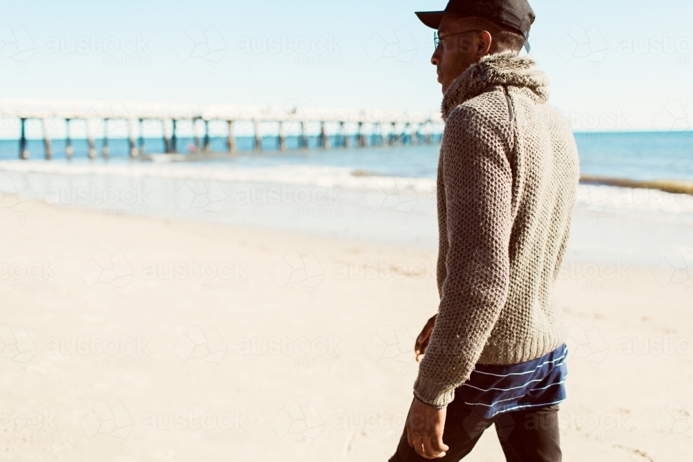 Young man walking away on the beach - Australian Stock Image