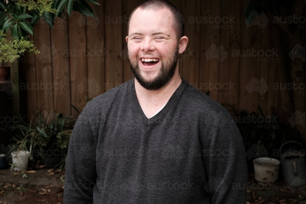 Image of Young Man with Down Syndrome Laughing Heartily - Austockphoto