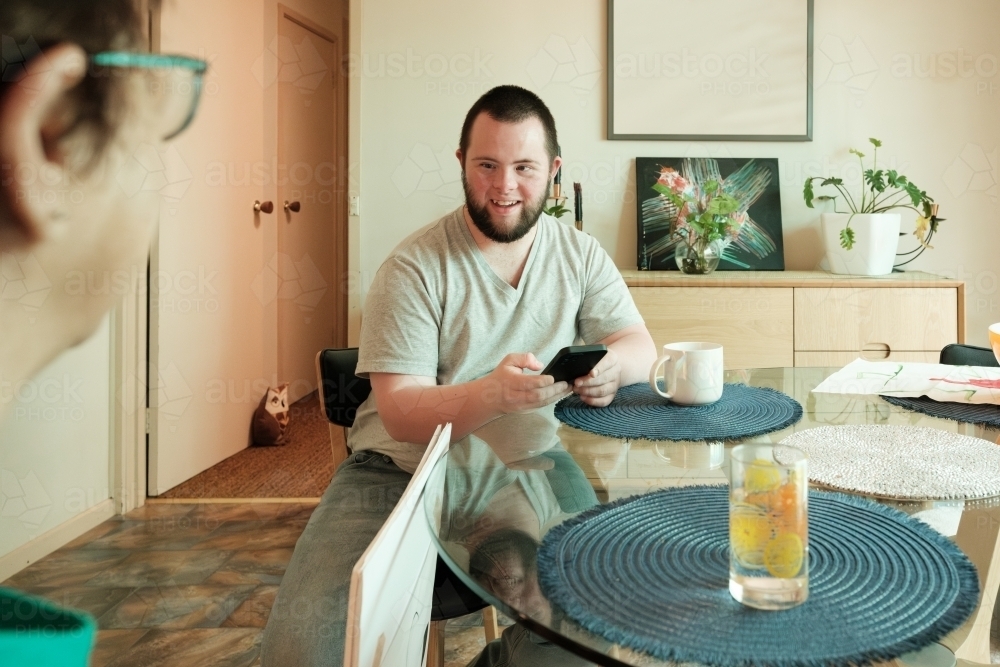 Young Man with Down Syndrome Talking with a Woman - Australian Stock Image