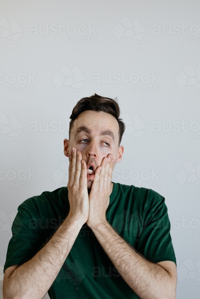 Young man, Worried look, green shirt - Australian Stock Image