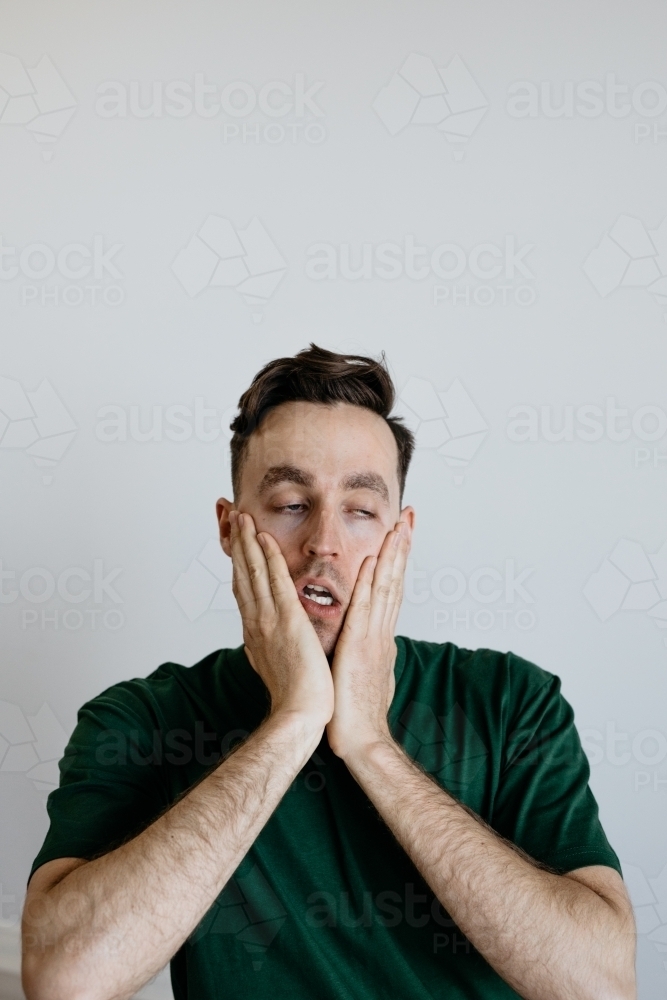 Young man, Worried look, green shirt. - Australian Stock Image