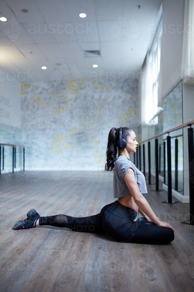 Young Maori dancer stretching at dance studio - Australian Stock Image
