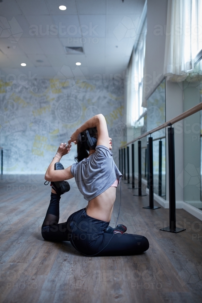 Young Maori dancer stretching at dance studio - Australian Stock Image