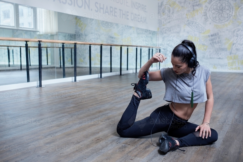 Young Maori dancer stretching at dance studio - Australian Stock Image