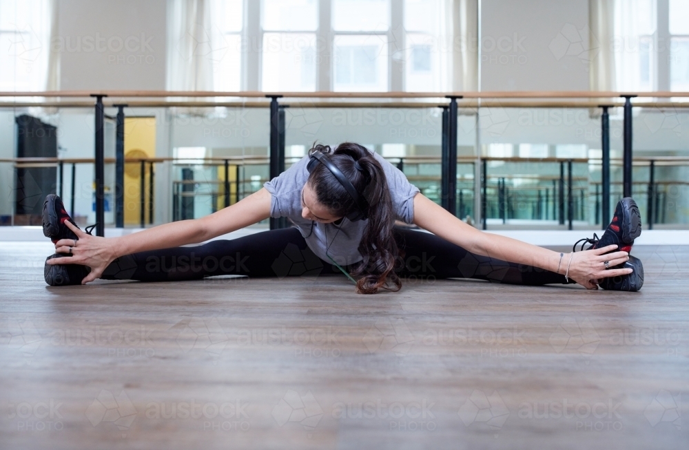 Young Maori woman stretching in dance studio - Australian Stock Image