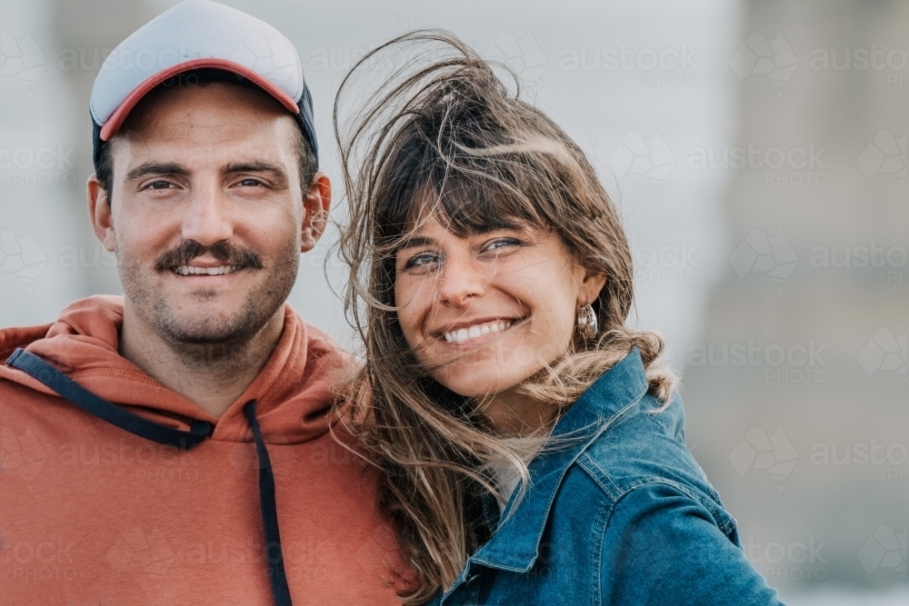 Young mid twenties couple smile in the wind. - Australian Stock Image
