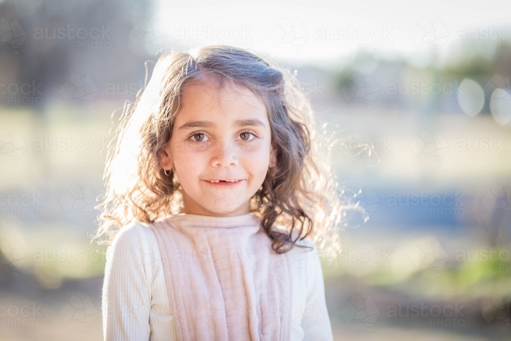 Young mixed race aboriginal and caucasian girl outside smiling - Australian Stock Image
