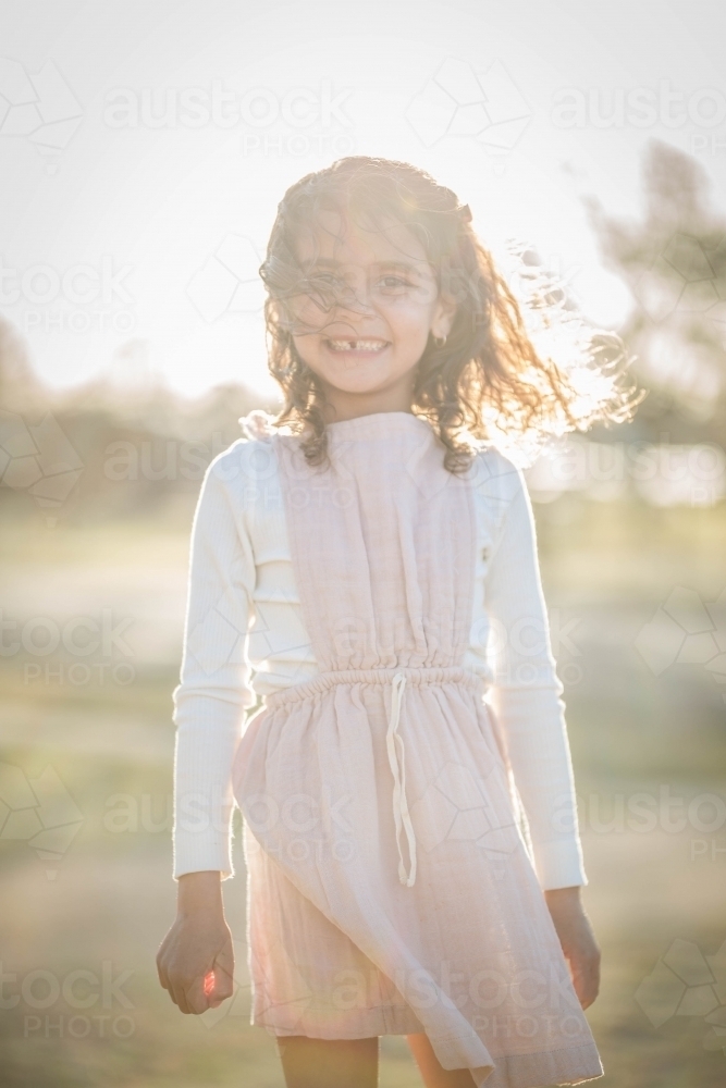 Young mixed race aboriginal and caucasian girl smiling in afternoon light - Australian Stock Image