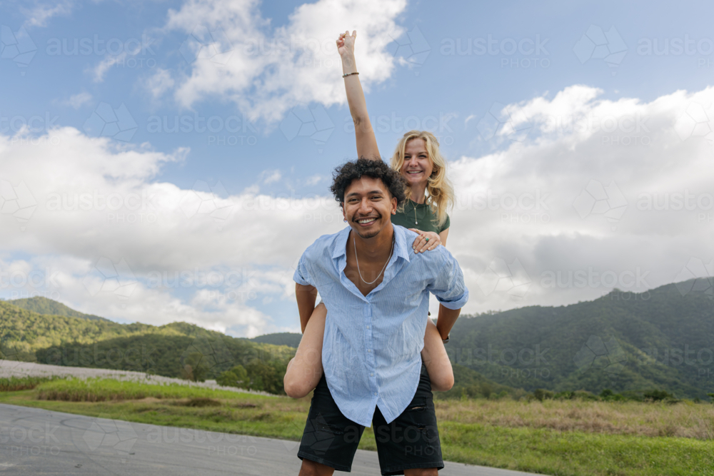Young mixed race couple having fun during a piggyback ride - Australian Stock Image