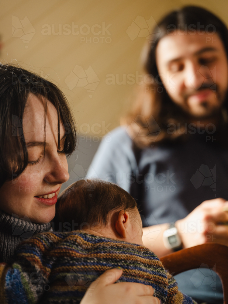Young mother holding baby dressed in striped sweater - Australian Stock Image