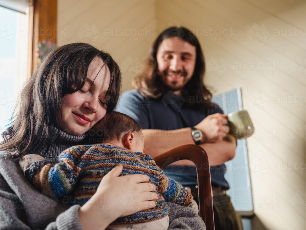 Young mother holding baby dressed in striped sweater - Australian Stock Image